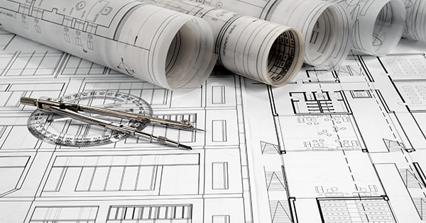 A collection of rolled up architectural plans on a table